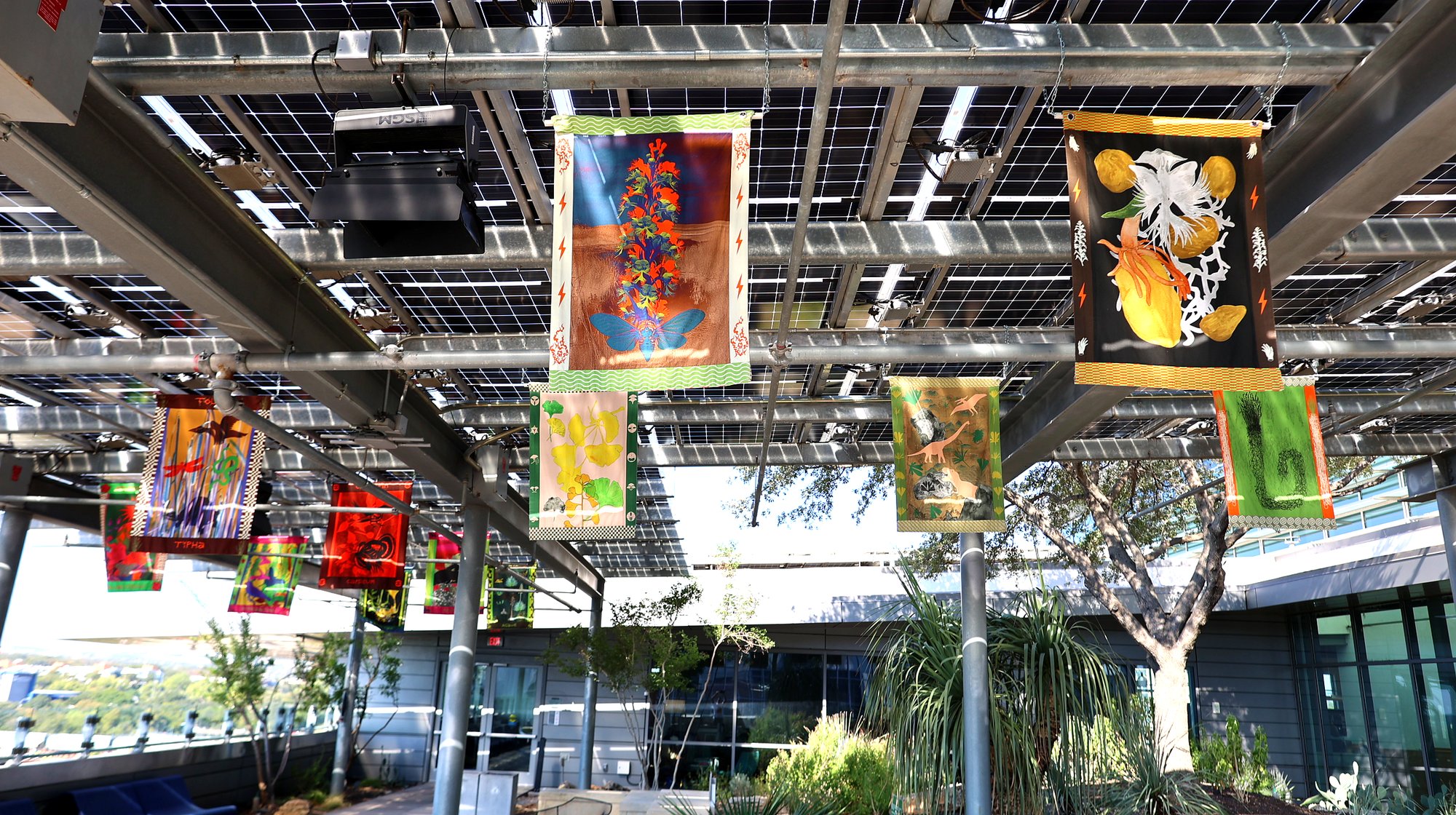 Vibrant tapestries suspended under solar panel canopy