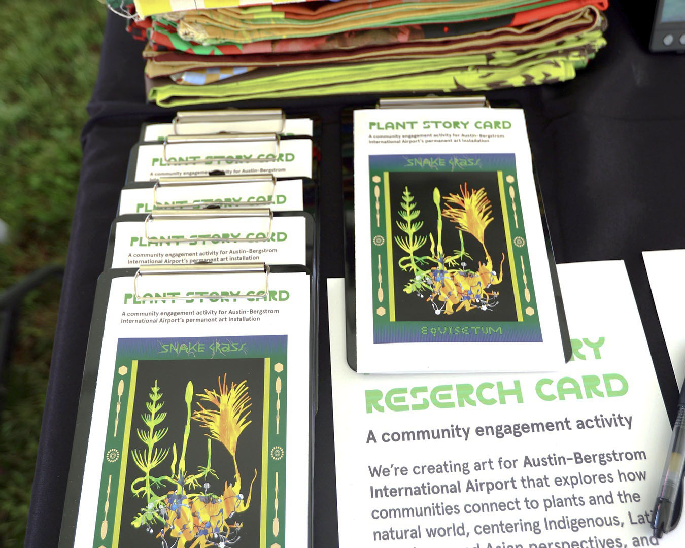 Plant Story Cards clipped to boards on an outdoor table, ready for people to fill in.